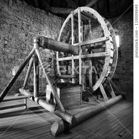 Big wooden millstone wheel in the castle Big wooden millstone wheel in the castle 110009848