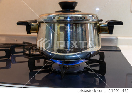 metal pot heated on gas stove metal pot heated on gas stove 110011483