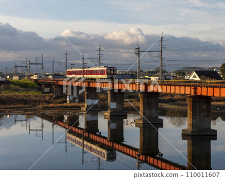 Kintetsu Myoji Line train crossing the Yamato River illuminated by the morning sun Kintetsu Myoji Line train crossing the Yamato River illuminated by the morning sun 110011607