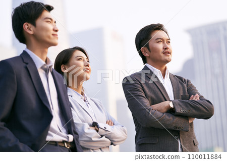 team of three asian businesspeople talking chatting discussing business outdoors team of three asian businesspeople talking chatting discussing business outdoors 110011884