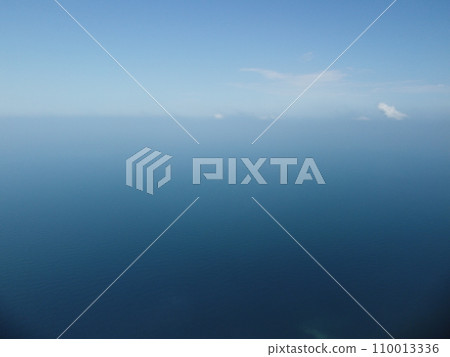 Aerial view from above on calm azure sea and volcanic rocky shores. Small waves on water surface in motion blur. Nature summer ocean sea beach background. Nobody. Holiday, vacation and travel concept 110013336
