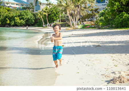 boy walking on the sandy beach 110013641