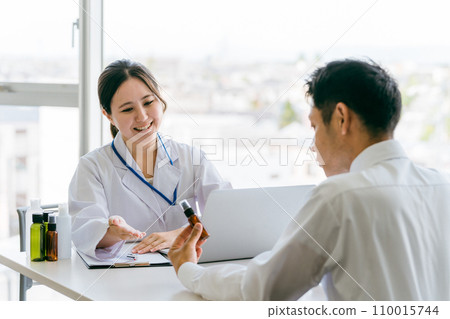 Doctor recommending medicine / Doctor and middle-aged man patient (medication guidance, hair loss treatment, AGA, drugs) 110015744