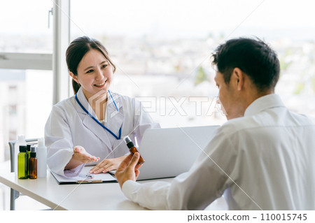 Doctor recommending medicine / Doctor and middle-aged man patient (medication guidance, hair loss treatment, AGA, drugs) 110015745