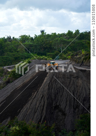 A stone quarry in Indonesia. Large equipment such as bulldozers and dump trucks are working on the site. 110015808