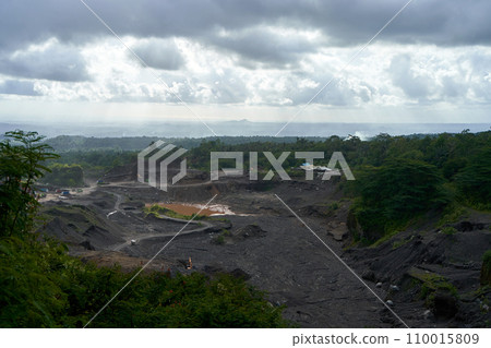 A stone quarry in Indonesia. Large equipment such as bulldozers and dump trucks are working on the site. 110015809
