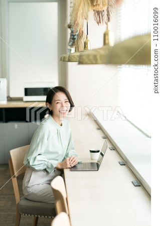 A woman working at a cafe counter A woman working at a cafe counter 110016099