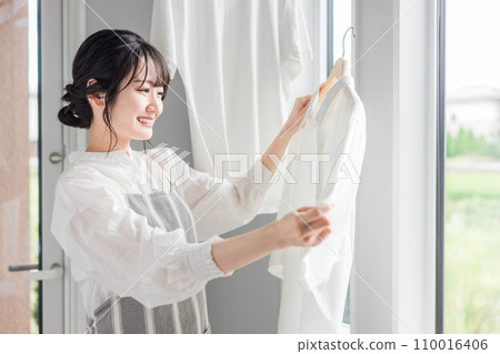 Woman drying laundry (housework, housewife, detergent, fabric softener, bleach) 110016406