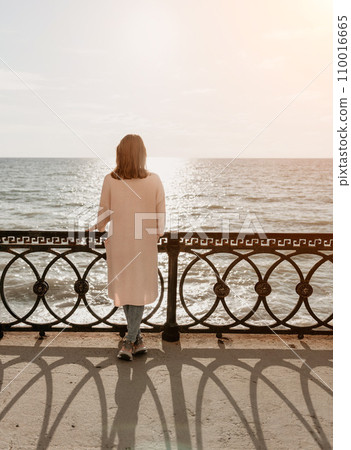 Woman summer travel sea. Happy tourist enjoy taking picture outdoors for memories. Carefree woman traveler posing on beach at sea on sunset, sharing travel adventure journey. Holiday vacation concept. Woman summer travel sea. Happy tourist enjoy taking picture outdoors for memories. Carefree woman traveler posing on beach at sea on sunset, sharing travel adventure journey. Holiday vacation concept. 110016665