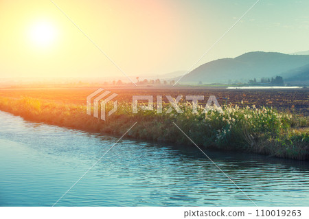 Mountain landscape in the evening. Stream against mountains. The Hula Valley in northern Israel at sunset 110019263