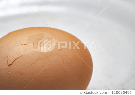 Chicken egg with cracked shell close up 110020495
