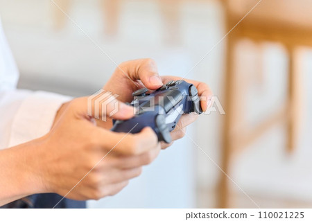 Asian man playing games in the living room 110021225