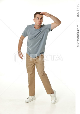 young man looking far away at distance with hand over head on white background young man looking far away at distance with hand over head on white background 110021449