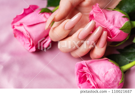 Female hands with pink nail design hold pink roses Female hands with pink nail design hold pink roses 110021687