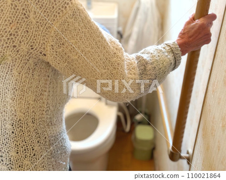 Elderly woman's hand holding the handrail to enter a Western-style toilet Elderly woman's hand holding the handrail to enter a Western-style toilet 110021864