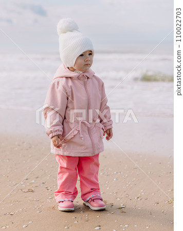Cute girl walk on ocean coastline. California winter holidays concept. 110022703