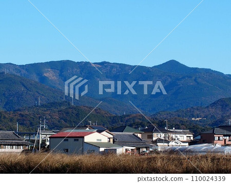 藍天、鱗次櫛比的房屋、四國山脈（土贊線附近的高町平原風景） 110024339