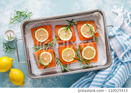 Salmon. Fresh raw salmon fish fillet with cooking ingredients, rosemary and lemon, top view 110025415