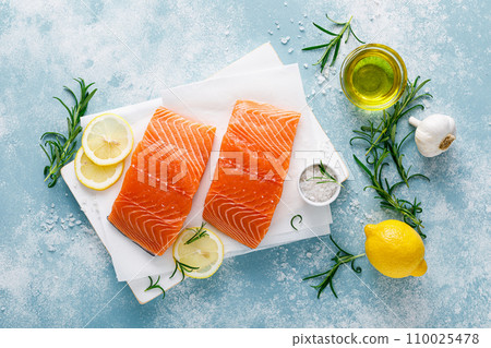 Salmon. Fresh raw salmon fish fillet with cooking ingredients, herbs and lemon, top view 110025478