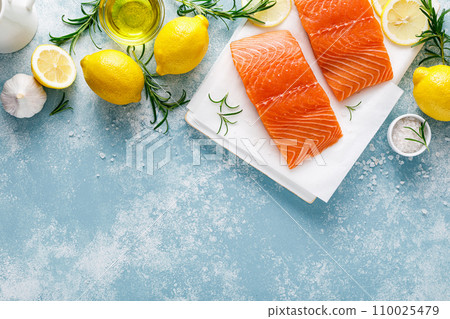 Salmon. Fresh raw salmon fish fillet with cooking ingredients, herbs and lemon, top view 110025479