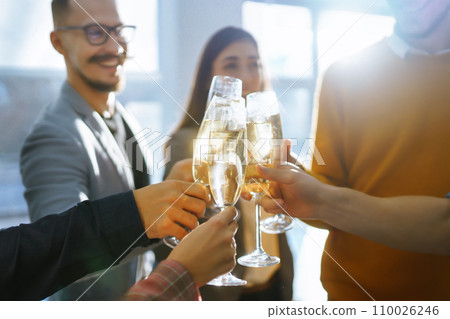 Clinking glasses with champagne. Happy coworkers celebrating their business achievement. 110026246