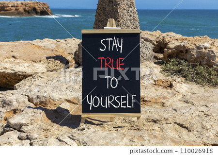 Stay true to yourself symbol. Concept word Stay true to yourself on beautiful black chalk blackboard. Beautiful red stone blue sea background. Business stay true to yourself concept. Copy space Stay true to yourself symbol. Concept word Stay true to yourself on beautiful black chalk blackboard. Beautiful red stone blue sea background. Business stay true to yourself concept. Copy space 110026918