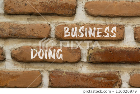 Doing business symbol. Concept words Doing business on beautiful brown bricks. Beautiful brick wall background. Beautiful brick wall. Business, motivational Doing business concept. Copy space. 110026979