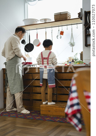 Father and son cooking, rear view 110027073