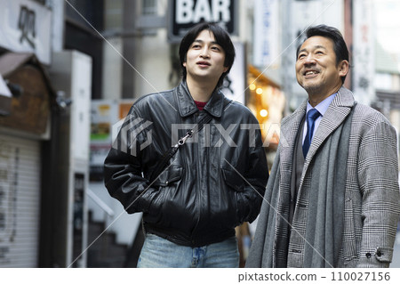 A man in his 50s goes out for a drink with his son. 110027156