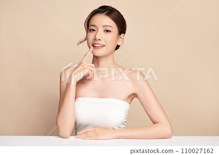Beautiful young asian woman with clean fresh skin on beige background, Face care, Facial treatment, Cosmetology, beauty and spa, Asian women portrait. Beautiful young asian woman with clean fresh skin on beige background, Face care, Facial treatment, Cosmetology, beauty and spa, Asian women portrait. 110027162