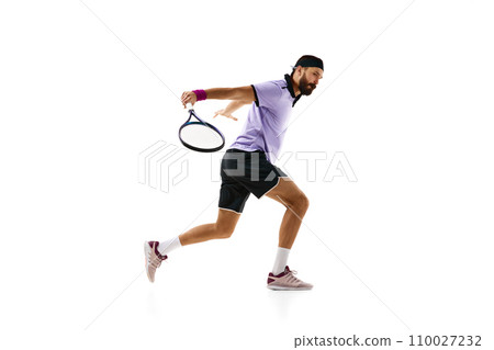 Dynamic image of bearded athletic man, tennis player in motion with racket during game, practicing isolated over white background. Sport, competition 110027232