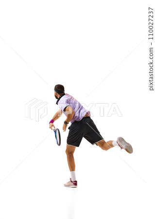 Competitive athletic man, tennis player during game in motion with racket, playing isolated over white background. Sport, competition Competitive athletic man, tennis player during game in motion with racket, playing isolated over white background. Sport, competition 110027237