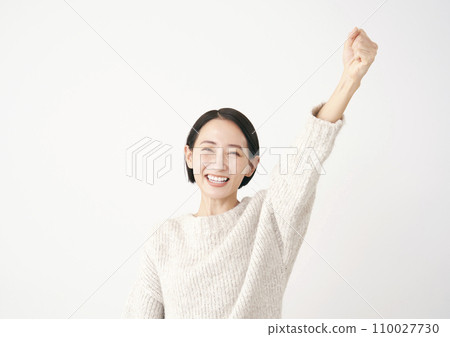 Middle-aged woman doing a fist pump, white background 110027730