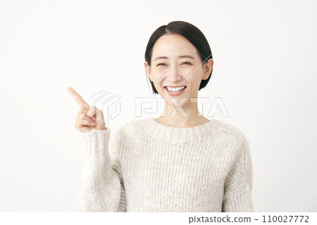 Middle-aged woman pointing to the left white background Middle-aged woman pointing to the left white background 110027772
