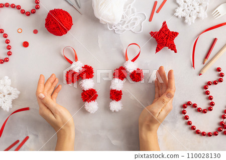 Making pom-poms from red and white threads. Ideas of Christmas decoration diy with kids. Candies 110028130
