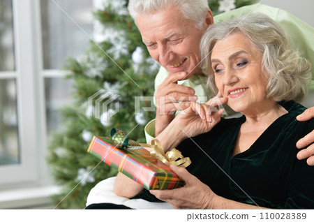 Happy elderly couple celebrating new year at home Happy elderly couple celebrating new year at home 110028389
