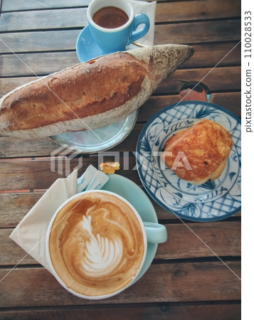 Sourdough bread and chocolate croissant paired with cappuccino and espresso, rustic autumn aesthetic Sourdough bread and chocolate croissant paired with cappuccino and espresso, rustic autumn aesthetic 110028533