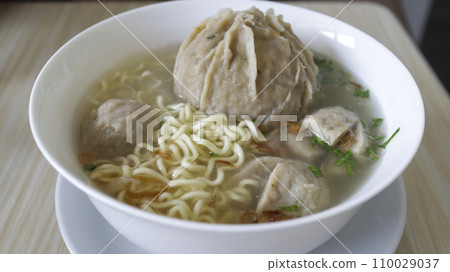 Indonesian famous foodstreet Bakso or baso is a meatballs served with the soup if beef broth, noodle, additional soy sauce and some chilli sauce. 110029037