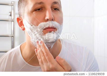 Man's face applying facial foam, close-up. Shaving cream, skin care Man's face applying facial foam, close-up. Shaving cream, skin care 110029939