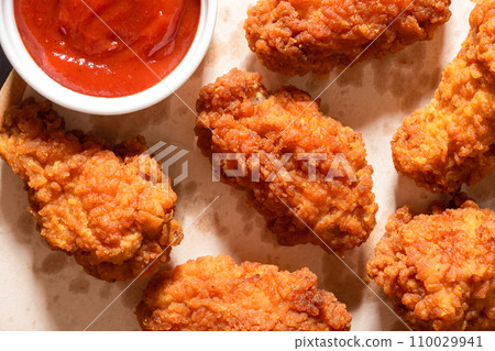 Delicious crispy breaded chicken breast strips on the table. View from above Delicious crispy breaded chicken breast strips on the table. View from above 110029941