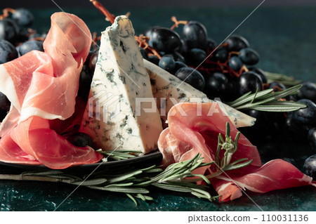 Prosciutto with blue cheese, grapes, and rosemary. Prosciutto with blue cheese, grapes, and rosemary. 110031136