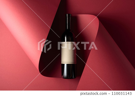 Bottle of red wine with old empty label on a red background. 110031143
