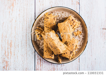 Close up of sweet dessert halva from sunflower seeds with flax seeds on a plate top view Close up of sweet dessert halva from sunflower seeds with flax seeds on a plate top view 110031331