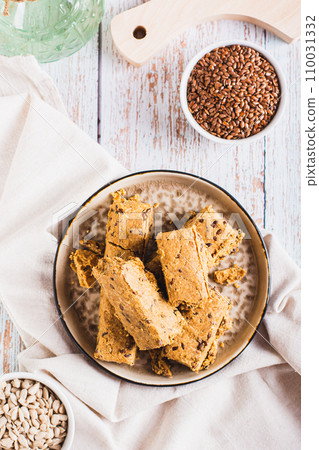 Pieces of halva with flax seeds on a plate on the table top and vertical view Pieces of halva with flax seeds on a plate on the table top and vertical view 110031332