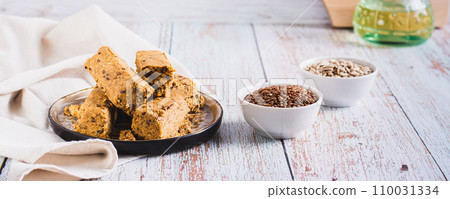 Sweet dessert halva from sunflower seeds with flax seeds on a plate web banner Sweet dessert halva from sunflower seeds with flax seeds on a plate web banner 110031334