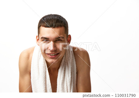 Morning routine. Handsome shirtless young man with towel on shoulders, washing face against white studio background Morning routine. Handsome shirtless young man with towel on shoulders, washing face against white studio background 110031790