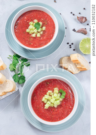 Cold soup Gazpacho garnished with cucumber and cilantro, in bowl, vertical top view Cold soup Gazpacho garnished with cucumber and cilantro, in bowl, vertical top view 110032182