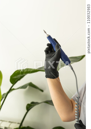 Electric nail file drill manicure machine with fraser close up on light background with copy space Electric nail file drill manicure machine with fraser close up on light background with copy space 110032983