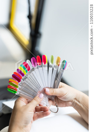 Collection of nails color polish samples. A palette of nail designs of different colors with gel polish. Transparent tips with nail polish samples. Demonstration fan-shaped palette of color shades. Collection of nails color polish samples. A palette of nail designs of different colors with gel polish. Transparent tips with nail polish samples. Demonstration fan-shaped palette of color shades. 110033228