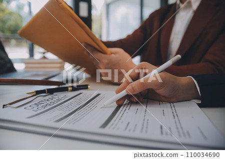 Lawyer, legal advisor, businessman brainstorming information on agreement details Business contracts in legal processing books for accuracy in contract documents. joint financial investment. 110034690